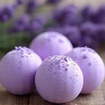 Bômbas de banho roxas com flores de lavanda ao fundo